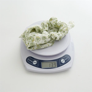 Close-up of floral scrunchie with rabbit ears showing the texture and 13.9g weight