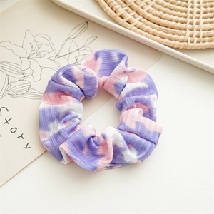 Detailed close-up of a tie-dye scrunchie with soft purple and pink knit fabric textures
