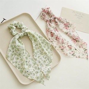 Detail of floral chiffon scrunchies with long streamers in green and pink pastel tones