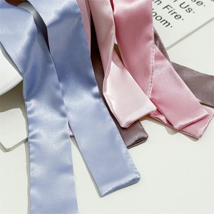 Detail shot of premium silky satin fabric texture and stitching on colorful hair bows