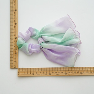 Tie-dye chiffon bow hair scrunchie in purple and mint green gradient with ruler
