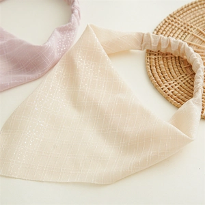 Close-up of glitter fabric triangle headbands with elastic bands in beige and pink