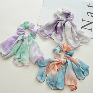 Three tie-dye chiffon scrunchies with long scarves in purple, blue, and green tones