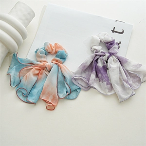 Detailed view of tie-dye chiffon bow hair scrunchies with long flowing ribbons in soft pastel