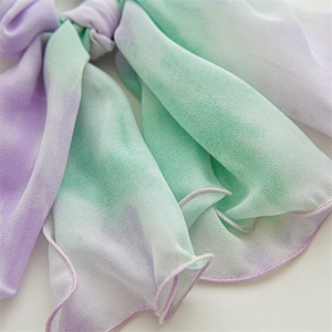 Close-up of chiffon double-layer bow scrunchie with purple and green gradient pattern