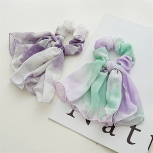 Detailed shot of tie-dye chiffon bow scrunchies with elegant flowing long streamers