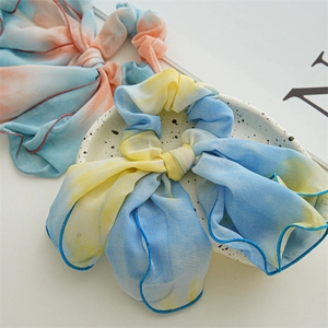 Detail of tie-dye chiffon scrunchie with long ribbons and neat overlock edge craft