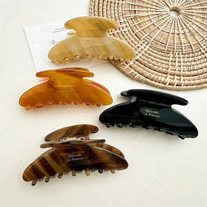 Set of four elegant acetate hair claws in amber, tortoise, and neutral tones