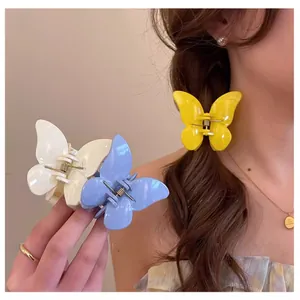 Vue macro détaillée de pinces à cheveux papillon pastel en résine lisse avec ressort en métal