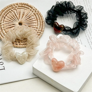 Three mesh scrunchies with marble heart pendants in black, beige, and soft pink colors