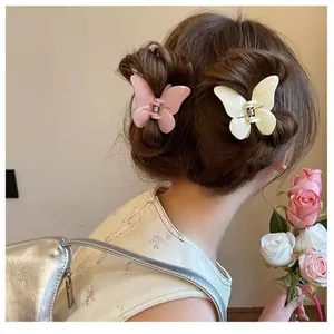 Détail de la coiffure avec des pinces à cheveux papillon en rose et beige sur cheveux longs