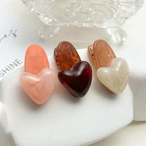 Lot de trois barrettes à cheveux en forme de cœur avec texture marbrée sur un socle blanc