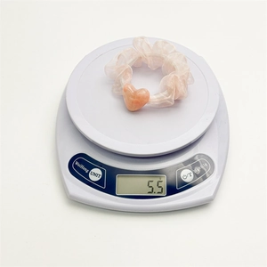 Pink mesh organza scrunchie with peach heart charm on a scale weighing 5.5g