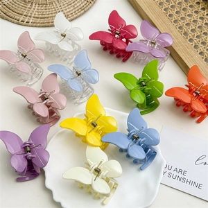 Vue détaillée de pinces à cheveux papillon colorées aux tons pastel de macaron doux