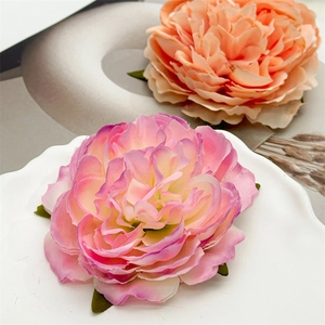 Dettaglio di un fermaglio per capelli a forma di peonia con petali in tessuto realistici