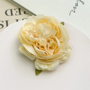 Dettaglio dell'elegante fermaglio per capelli a forma di peonia color crema e foglie