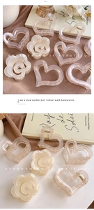 Detailed macro view of heart and flower resin hair claws with pearlescent finish
