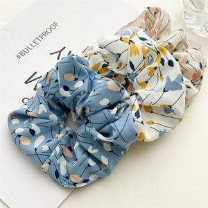 Detail of floral pattern on two high-elastic fabric scrunchies in pastel colors