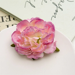 Dettaglio del fermaglio per capelli a peonia in seta con petali rosa su un piatto