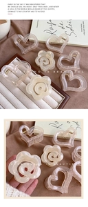 Detail of cream resin hair clips in heart and flower shapes on a jewelry tray