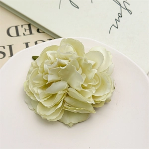 Dettaglio del fermaglio per capelli con peonia color crema e petali in tessuto eleganti
