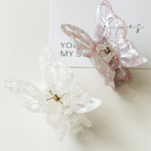 Detailed macro view of hollow butterfly hair claws in pink marble and silver glitter finish