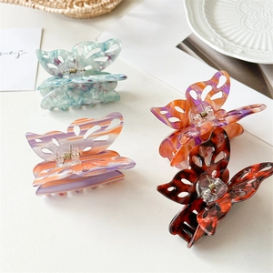 Large hollow butterfly hair claw clips in marble and amber acetate finishes