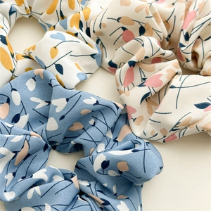 Close-up of floral scrunchies set featuring detailed fabric texture and elastic design