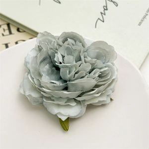 Dettaglio elegante fermaglio per capelli a forma di peonia blu polvere su un piatto di porcellana
