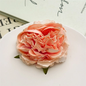 Dettaglio della clip per capelli a forma di peonia rosa corallo con petali in tessuto