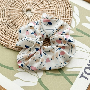 Macro detail of large floral chiffon scrunchie with pink hearts and high elasticity