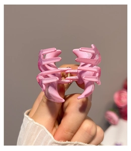 Detail der rosa matten Haarklammer mit Perlmutt-Effekt und goldener Metallfeder