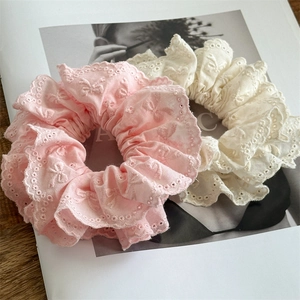 Detailsicht auf rosa und weiße hohle Spitzen-Scrunchies mit zarten Schmetterlingsstickereien