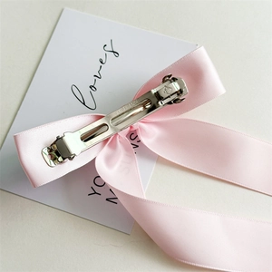 Barrette à cheveux avec nœud en satin rose et pince à ressort en métal argenté
