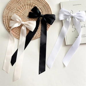 Detalle de elegantes pinzas para el pelo con lazo de satén en blanco y negro