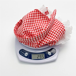 Détail du foulard à carreaux rouge et blanc pesant 29,5g sur une balance électronique