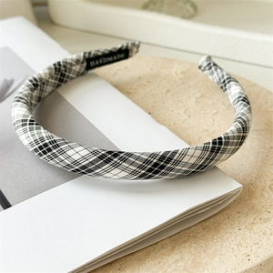 Détail d'un serre-tête en tissu à carreaux noir et blanc fait main avec étiquette tissée