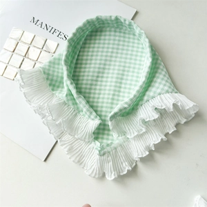 Détail du bandeau à carreaux verts avec bords à volants plissés blancs sur fond pur
