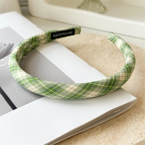 Détail d'un serre-tête en tissu à carreaux vert et blanc avec étiquette Handmade
