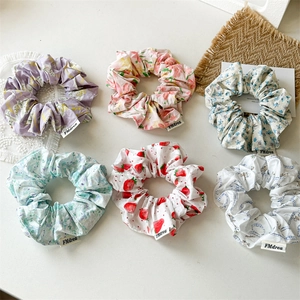 Detail of six floral pattern scrunchies with elegant fabric textures for hair styling
