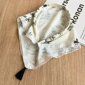 Close-up of ink wash bamboo print headscarf with delicate lace trim and silk tassel