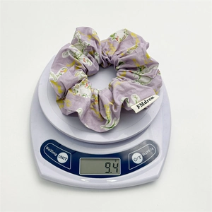 Detail shot of light purple floral scrunchie on scale showing lightweight 9.4g weight