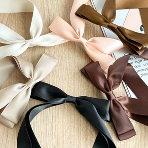 Détail des barrettes à nœuds en ruban de satin double couche en couleurs élégantes