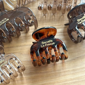 Detailed close-up of brown resin hair claw with gold Barrette La France lettering