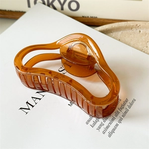 Close-up of a large amber translucent jelly claw clip with a sleek curved design