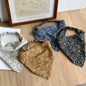 Detailed close-up of four floral elastic headscarves in cream, yellow, navy, and black colors