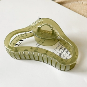 Close-up of translucent grass green wavy hair claw clip with a sleek modern design