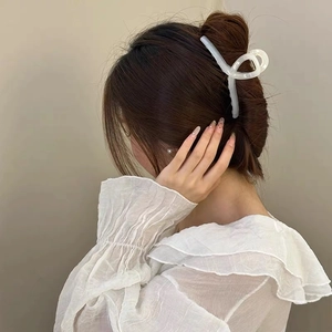 Minimalist white translucent hair claw clip shown on woman's updo hairstyle