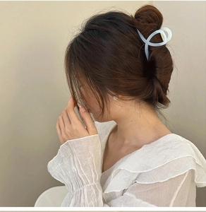 Detailed side view of an elegant marble texture hair claw clip in a stylish updo hairstyle