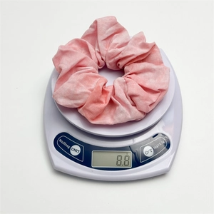 Pink tie-dye fabric scrunchie on scale showing lightweight 8.8g minimalist design